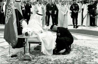 Maj. Gen. Abdulaziz Al-Fagham tying the shoe of King Salman.